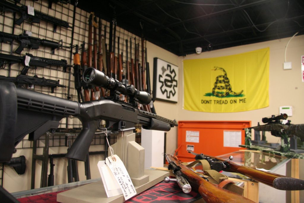 IMG_0421 A display of rifles in a gun shop, with a flag that says