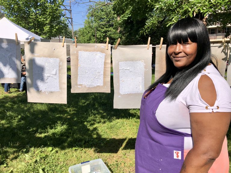 Latyra Blake, of The People's Paper Coop, an initiative of The Village's, helps community members make special paper with plant seeds embedded. Once the paper dries it can be buried to grow the plants.  (Darryl C. Murphy for WHYY)