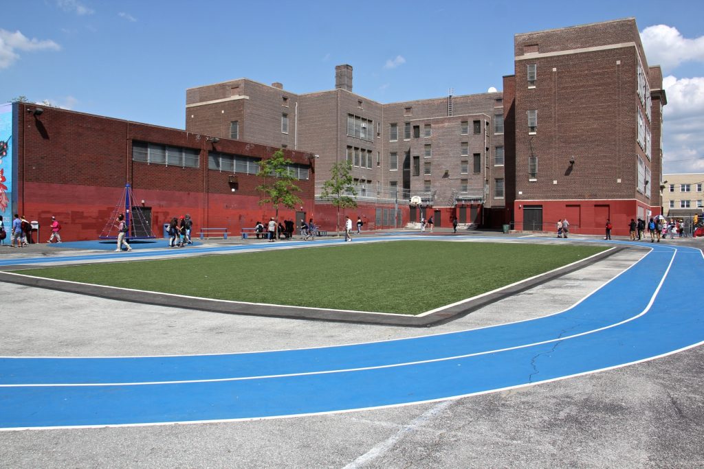 2018 05 07-e lee-south philadelphia taggart school-green stormwater infrastructure track An astroturf field and track direct rainwater runoff toward a containment basin in the recently rebuilt Taggart School playground in South Philadelphia.