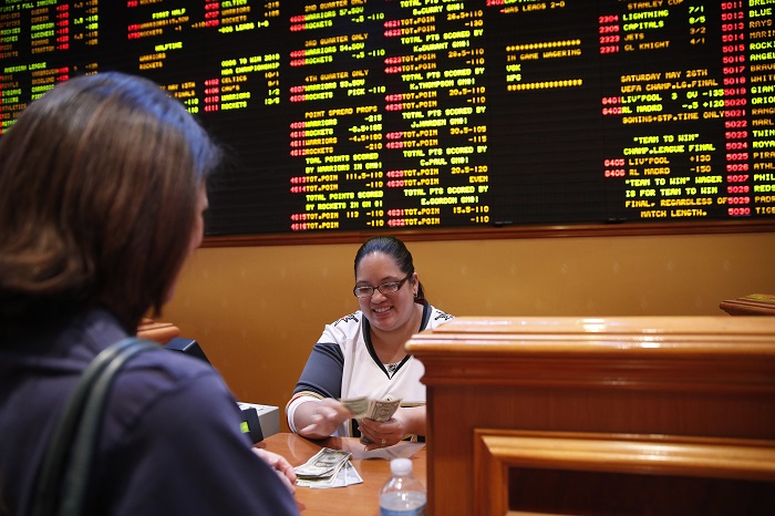 Supreme Court Sports Betting Crystal Kalahiki pays out a bet in the sports book at the South Point hotel-casino, Monday, May 14, 2018, in Las Vegas. The U.S. Supreme Court gave its go-ahead for states to allow gambling on sports across the nation, striking down a federal law that barred betting on football, basketball, baseball and other sports in most states. (John Locher/AP Photo)