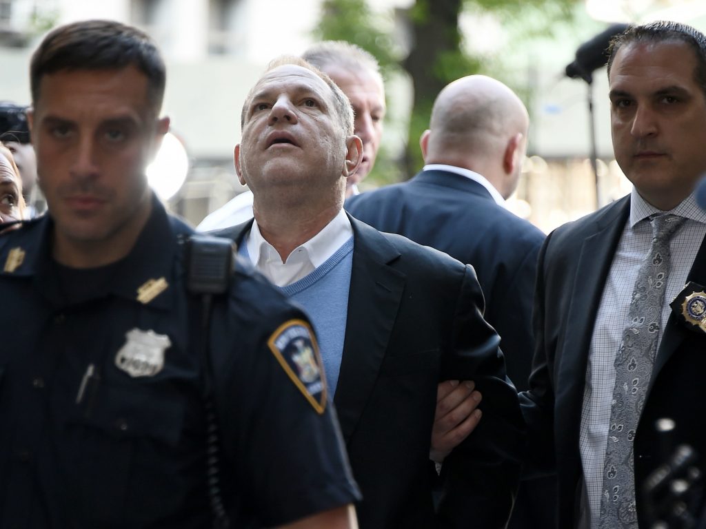 Law enforcement officers usher a handcuffed Harvey Weinstein into the courthouse for his arraignment in Manhattan on Friday.