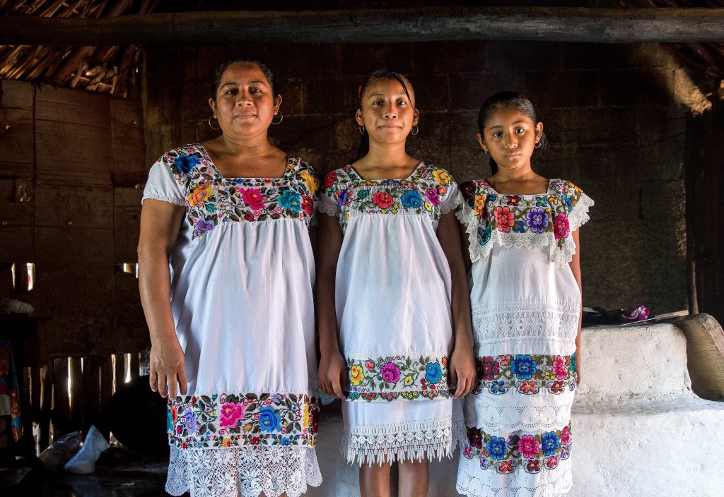 mex_azehbrauskas02-2 Maria de los Angeles Tun Burgos with daughters Angela, 12, and Gelmy, 9, in their family home in a Maya village in Yucatan, Mexico. (Adriana Zehbrauskas for NPR)