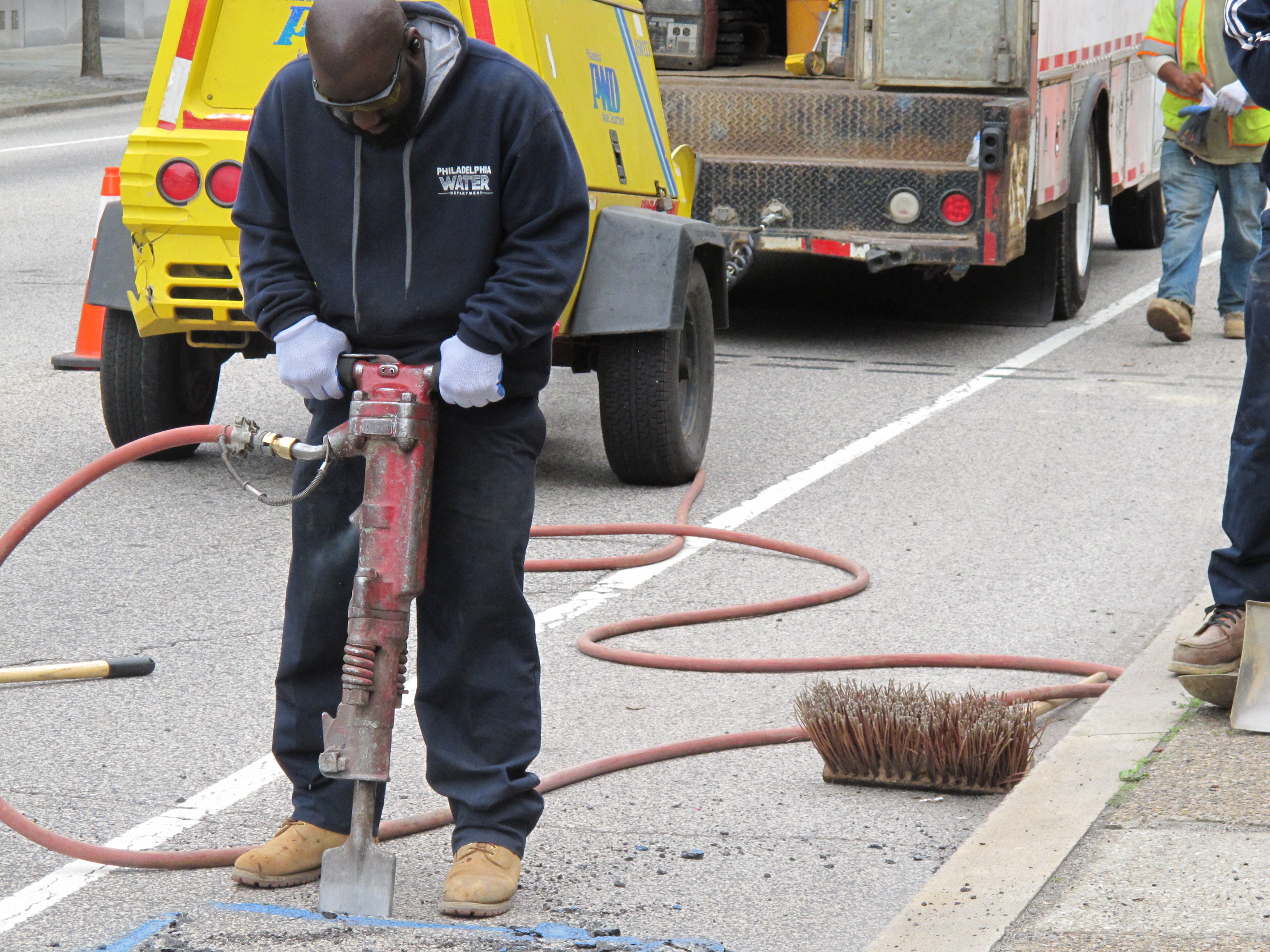 Water Department crews jackhammering open a street.