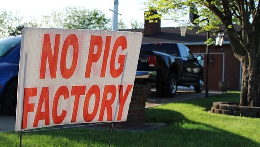 In this May 21, 2018 photo, a sign opposing an industrial hog farm is displayed at a home in Berwick, Pa. Residents who complain about foul smells from the nearby hog farm have taken their fight to the Pennsylvania Supreme Court. (Michael Rubinkam/AP Photo)