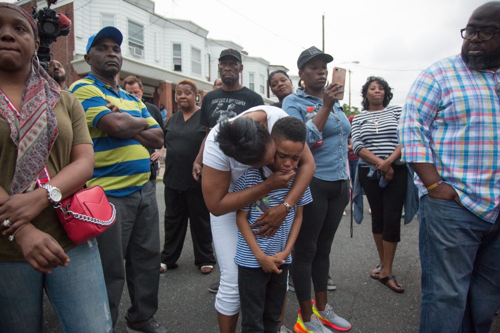 05 31 2018-ecohen-sandrea williams-17 Sakinah Crew comforts her 7-year-old son, Swyhir, during a rally to bring justice for the killing of Sandrea Williams. She was killed in a random act of gun violence outside of her mother’s home in West Philadelphia. Their teenage cousin was also injured by gunfire that night. (Emily Cohen for WHYY)
