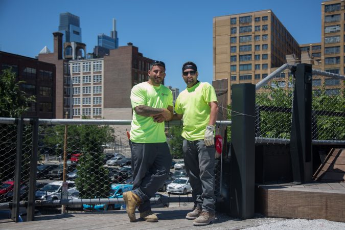 Giuseppe Giambanco (left) and James Postiglione, of AP Construction, make some final touches on the park they helped build June 14th 2018. (Emily Cohen for WHYY)