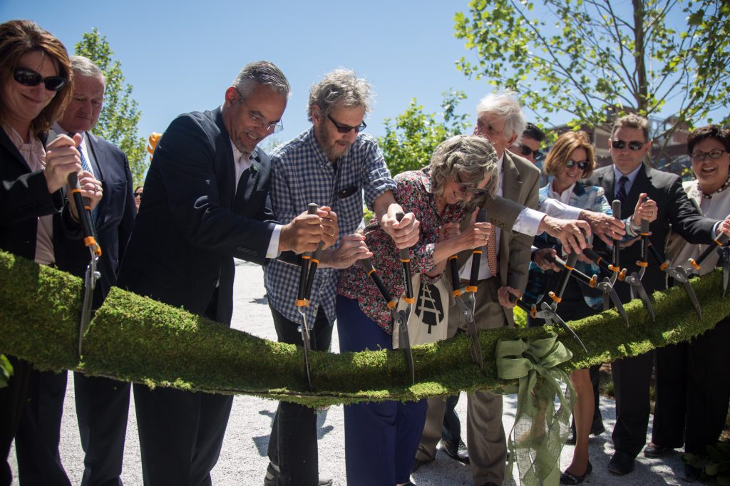 06 14 2018-ecohen-rail park opening-3 Integral members of the team that brought the rail park to life, including Sarah McEneaney (center) and John Struble (center left), cut the “green” ribbon, officially opening the first quarter mile of the Philadelphia Rail Park June 14th 2018. (Emily Cohen for WHYY)