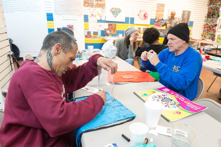 Kenan Nameli (left) and other workshop participants at the Kensington Storefront. Nameli lives in a nearby abandoned building, struggles with addiction, and said he has tried to enter into recovery a number of times. (Steve Weinik/Mural Arts)