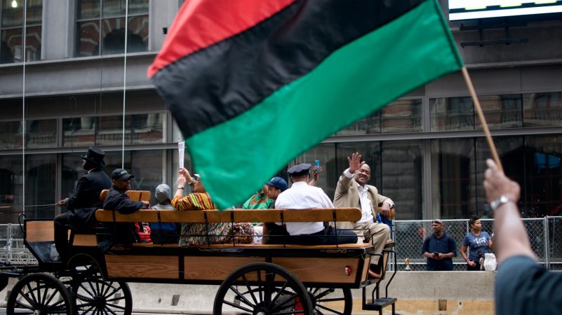 Congressman Dwight Evans representing Pennsylvania's 2nd District waves from the back of a horse-drawn carriage during the annual Juneteenth Parade on Market Street, on Saturday. (Bastiaan Slabbers for WHYY)