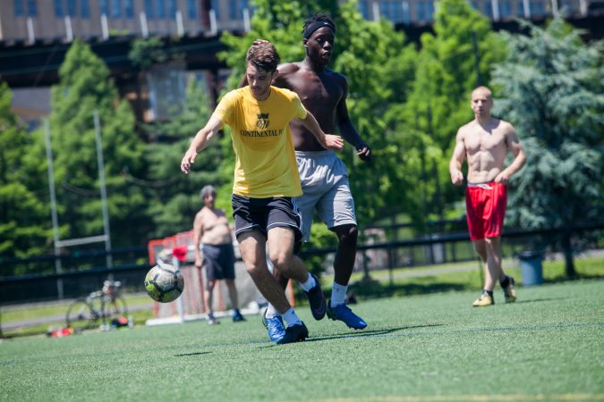 Players enjoy a game of pickup soccer at Penn Park on June 14, 2018. (Brad Larrison for WHYY)