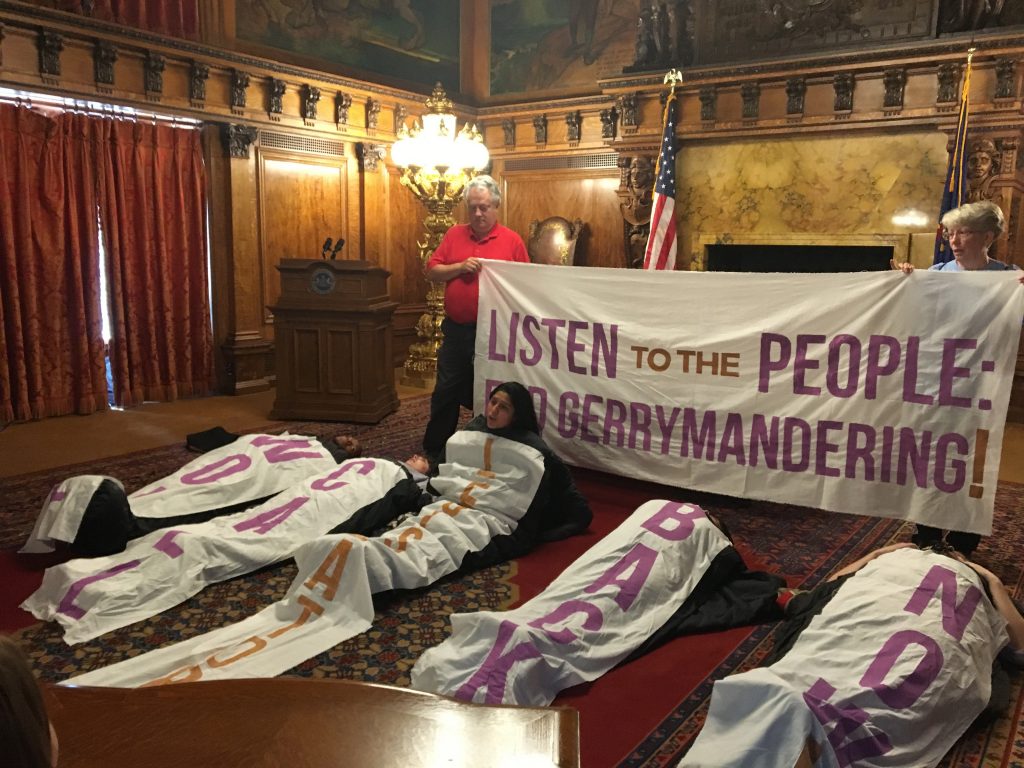 26redistricting_large Amid chants and songs, sleeping bag-clad protesters sat up one by one to give speeches in favor of congressional and state district maps drawn by citizens, not politicians.