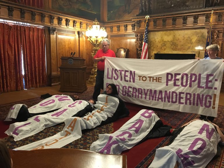 Amid chants and songs, sleeping bag-clad protesters sat up one by one to give speeches in favor of congressional and state district maps drawn by citizens, not politicians.