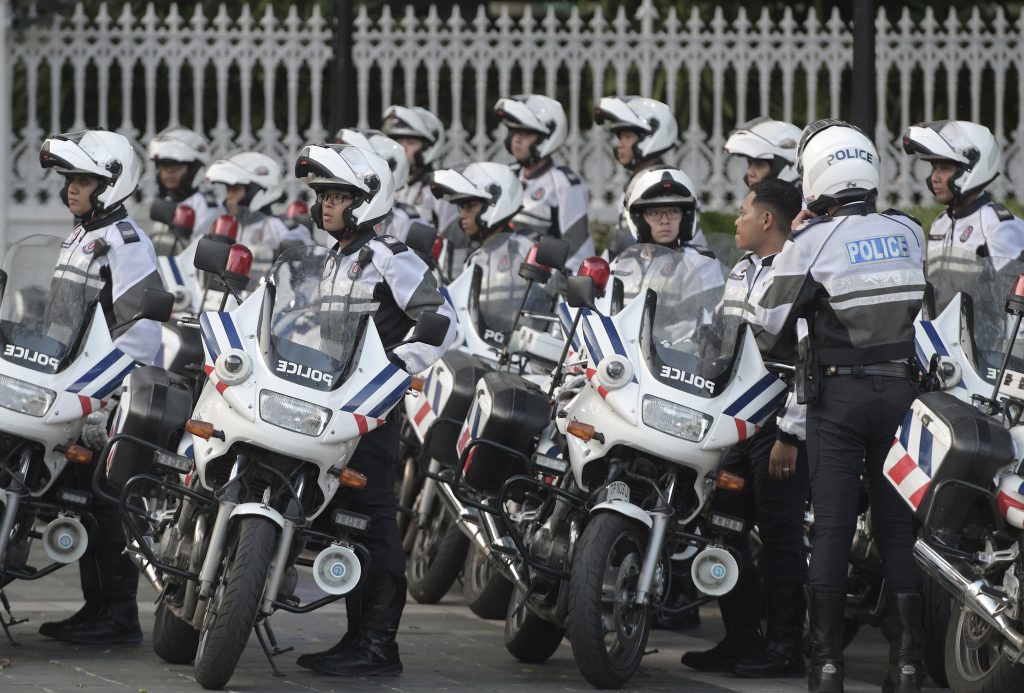 Singapore Trump Kim Summit Police officers escorting the motorcade of North Korea leader Kim Jong Un park after he arrives at the Istana, or Presidential Palace, in Singapore on Sunday, June 10, 2018, to meet Singapore Prime Minister Lee Hsien Loong. (AP Photo/Joseph Nair)
