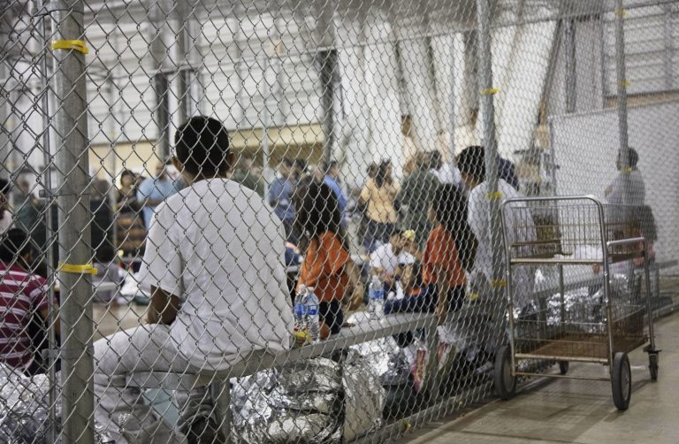 In this photo provided by U.S. Customs and Border Protection, people who've been taken into custody related to cases of illegal entry into the United States, sit in one of the cages at a facility in McAllen, Texas, Sunday, June 17, 2018.