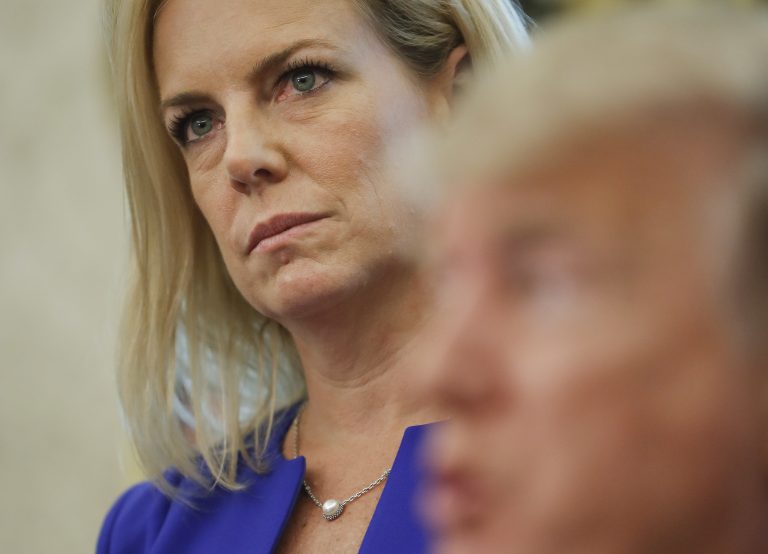 Homeland Security Secretary Kirstjen Nielsen, left, listens to President Donald Trump, right, speaks to members of the media after Trump signed an executive order to end family separations, during an event in the Oval Office of the White House in Washington, Wednesday, June 20, 2018.