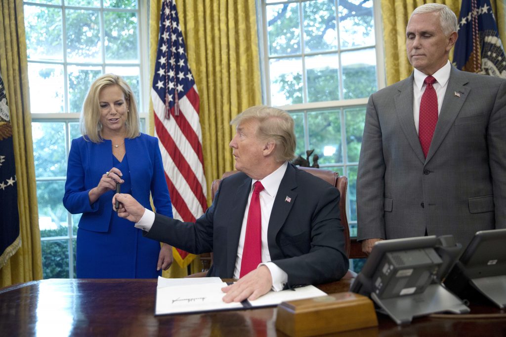 Donald Trump, Kirstjen Nielsen, Mike Pence In this June 20, 2018, photo, President Donald Trump gives the pen he used to sign the executive order to end family separations at the border to Homeland Security Secretary Kirstjen Nielsen, (left), as Vice President Mike Pence, (right), watches in the Oval Office of the White House in Washington. Nielsen has one hard-earned presidential signing pen, receiving hers after Trump used it to sign the executive order. By the time Trump reversed his policy Wednesday, Nielsen had been both yelled at and praised by Trump and pilloried for repeating his falsehoods. (Pablo Martinez Monsivais/AP Photo)