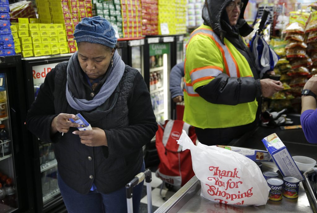 Faster Food Stamps A woman organizes her pocketbook after paying for groceries with an EBT card (Seth Wenig/AP Photo)