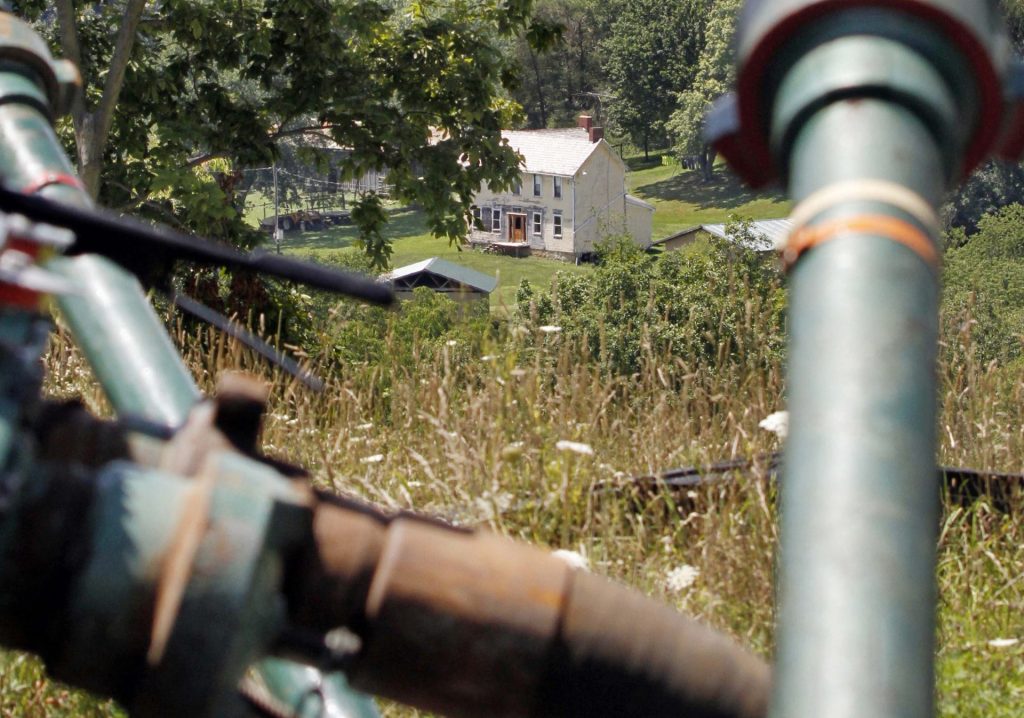 Range-Resources-pic-1920×1346 This July 27, 2011 file photo shows a farmhouse in the background framed by pipes connecting pumps where the hydraulic fracturing process in the Marcellus Shale was underway at a Range Resources site in Claysville, Pa. (Keith Srakocic/AP Photo)