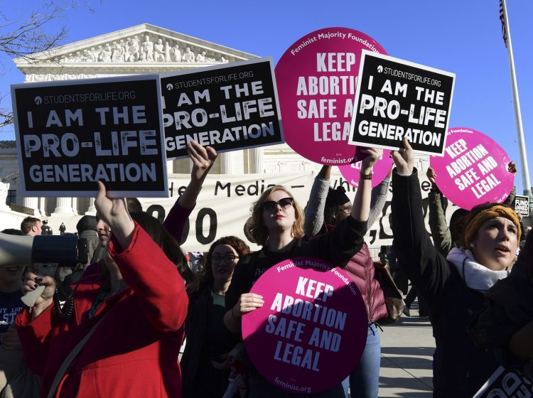 Protesters on both sides of the abortion issue gather outside the Supreme Court in Washington on Jan. 19 during the March for Life. (Susan Walsh/AP)