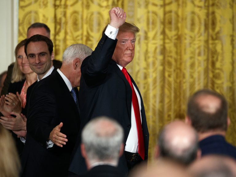 President Donald Trump pumps his fist as he leaves a meeting Monday in the East Room of the White House in Washington.