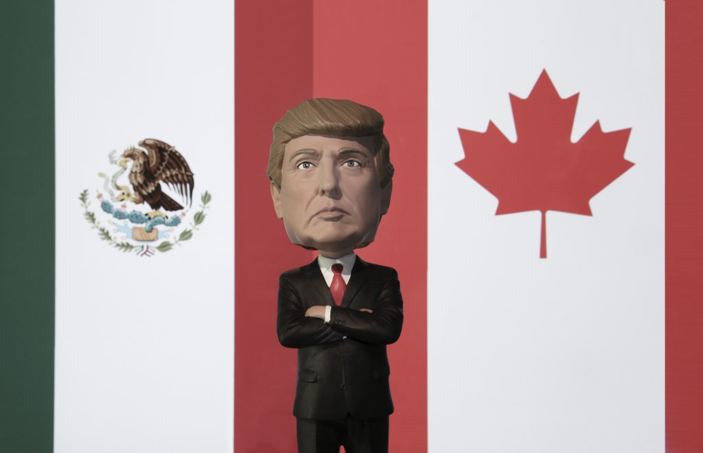 Bobble Head caricature of United States president Donald Trump s Bobble Head caricature of United States president Donald Trump standing between the flags of Mexico and Canada - NAFTA concept - North American Free Trade Agreement