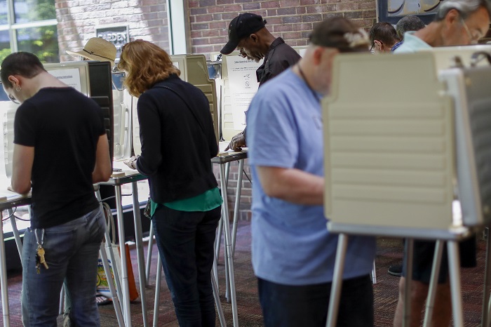 Voters fill out their ballots at the Cincinnati Public Library precinct on primary election day, Tuesday, May 8, 2018, in Cincinnati. Ohio's roller-coaster gubernatorial primary season will be decided Tuesday as Republicans and Democrats vote for their nominees to replace term-limited Republican Gov. John Kasich. (AP Photo/John Minchillo)