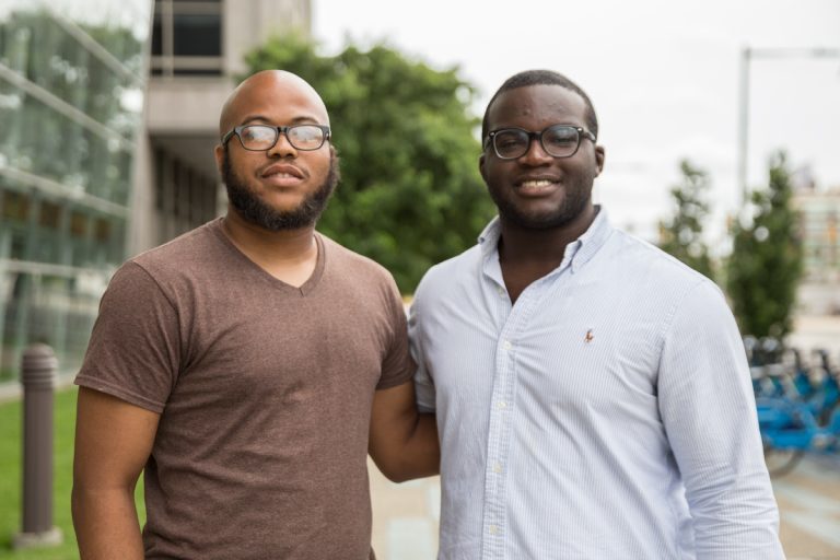 Farrad McLaughlin, (left), and Chris Felix, (right), are scholars from Philadelphia Futures, a program that helps first generation college students graduate. McLaughlin just earned his Master’s Degree from Cabrini University and Felix just graduated cum laude from Lafayette College. (Lindsay Lazarski/WHYY)
