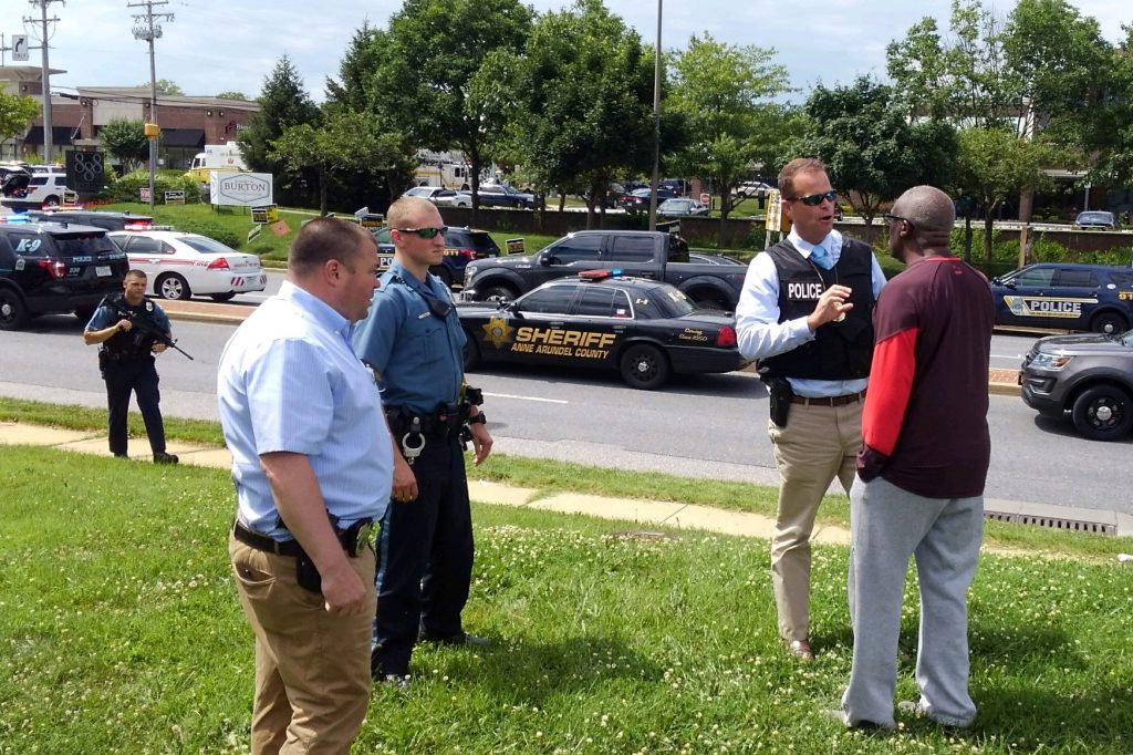 Police officers talk to a man as they respond to a shooting at the Capital Gazette newspaper in Annapolis, Md., on Thursday. Police officers talk to a man as they respond to a shooting at the Capital Gazette newspaper in Annapolis, Md., on Thursday. (Greg Savoy/Reuters)