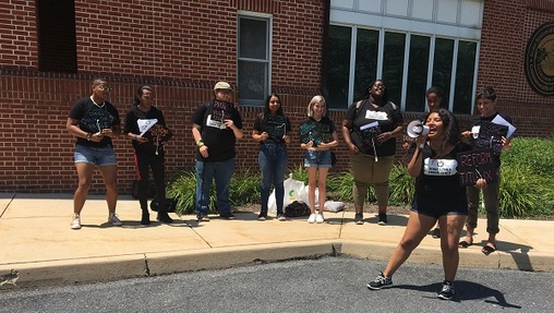 Outside the board of governors meeting, a small group of students rallied for, among other things, free higher education. (Katie Meyer/WITF)