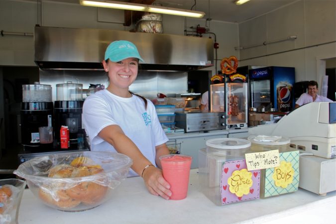 Ashley Cozzi serves up a smoothie without lid or straw at the Monmouth Beach Bathing Pavillion. (Emma Lee/WHYY)