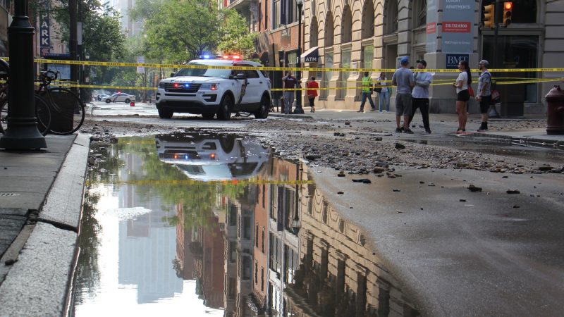 Police block traffic on Walnut Street left flooded and strewn with debris after a water main break. (Emma Lee/WHYY)