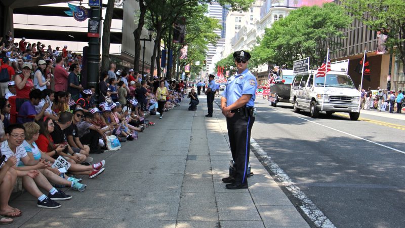 Philadelphia police stand guard along the Indepencence Day parade route on Market Street. (Emma Lee/WHYY)