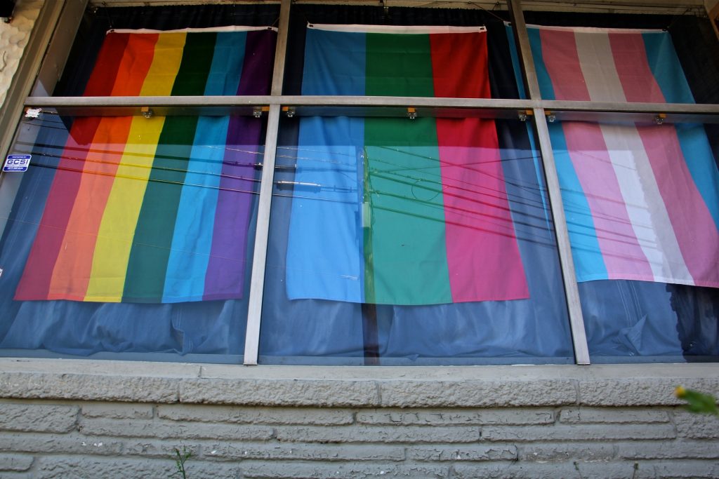 2018 07 09-e lee-new jersey somerdale-feminist apparel Flags hang in the windows of the headquarters of Feminist Apparel in Somerdale, New Jersey. (Emma Lee/WHYY)