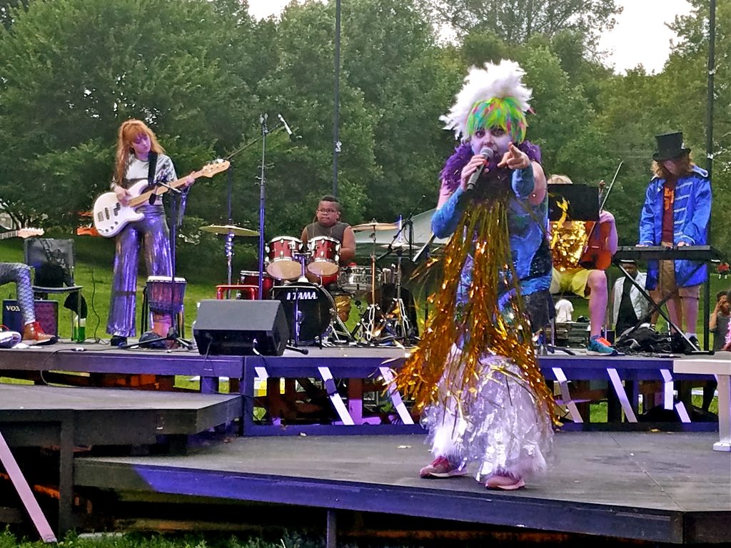 2018 07 22-p crimmins-philadelphia clark park-shakespeare glam rock Jess Conda, as Feste, fronts the band Midsummer Madness in a glam rock version of