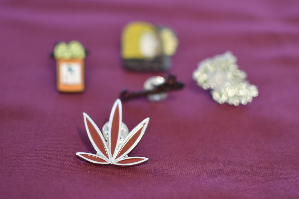 A pin of a stylized cannabis leaf lays on a table with information at a forum on the business of medicinal and recreational use of cannabis in the African-American community. (Bastiaan Slabbers for WHYY)