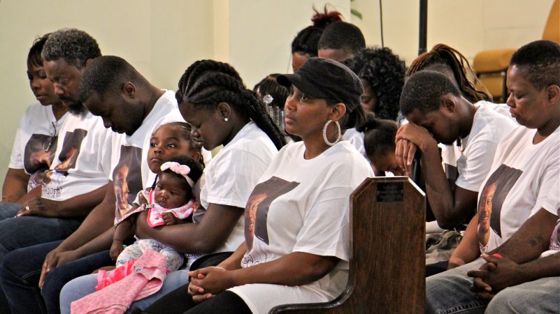 Family members of Michael White, 20, charged in the stabbing death of Sean Schellenger, 37, pray during a vigil at True Gospel Tabernacle in South Philadelphia. (Emma Lee/WHYY)