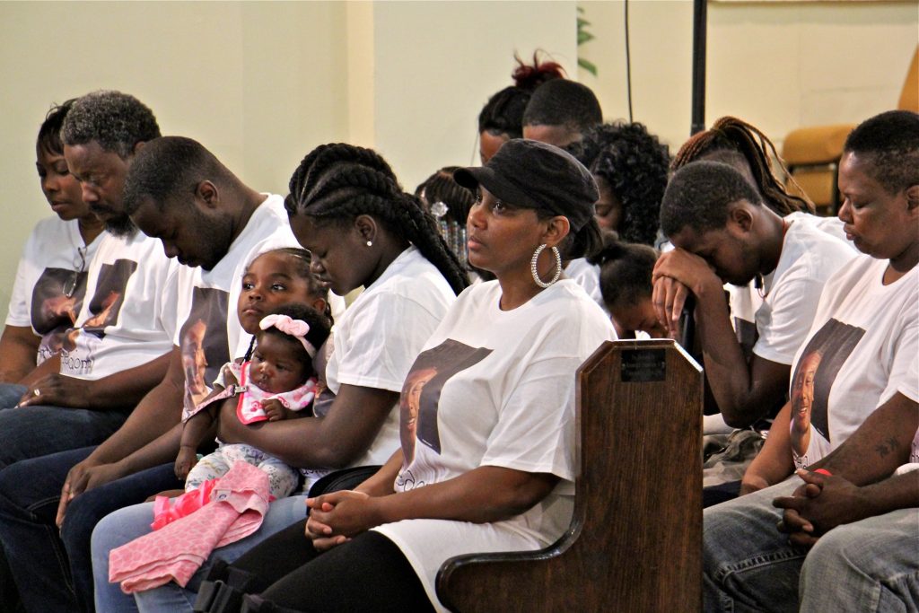 Family members of Michael White, 20, charged in the stabbing death of Sean Shellenger, 37, pray during a vigil at True Gospel Tabernacle in South Philadelphia.