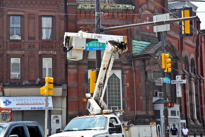 An electrician at Girard and Ridge avenues works from a crane in the midst of a heat wave with temperatures in the mid- to upper 90s expected throughout the week. (Kimberly Paynter/WHYY)