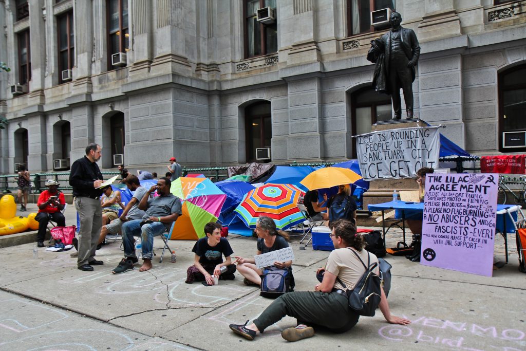 Immigration policy protesters have moved from the ICE headquarters at Eighth and Cherry streets to City Hall and are asking Philadelphia Mayor Jim Kenney to end an agreement with ICE. (Kimberly Paynter/WHYY)