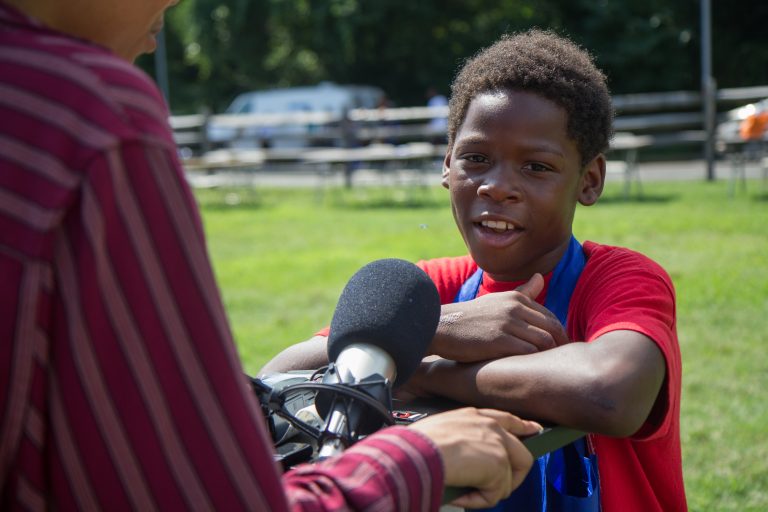 Eryn Greenwood, 10, from Eastwick, shares an experience he had with gun violence at the WURD event at Bartram’s Garden. (Kimberly Paynter/WHYY)