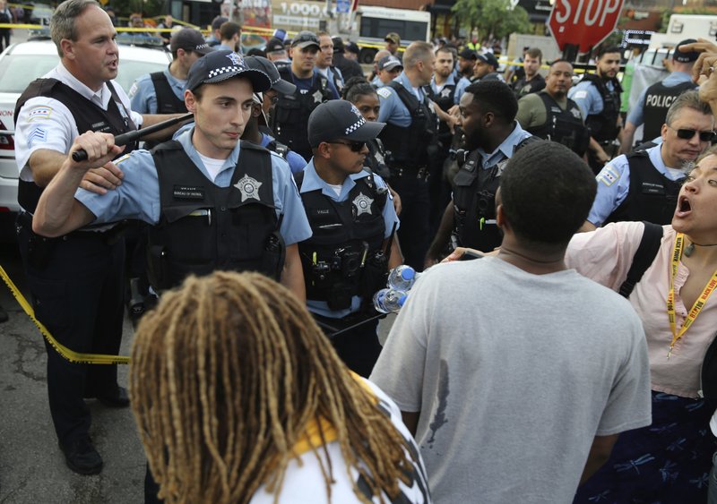 800 Members of the Chicago Police Department interact with an angry crowd at the scene of a police involved shooting in Chicago, on July 14. (Nuccio DiNuzzo/Chicago Tribune via AP)