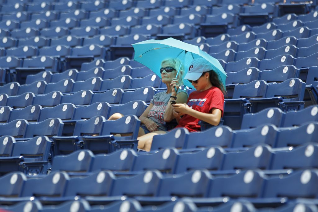 Nationals Phillies Baseball Fans find shade under an umbrella before the start of the Philadelphia Phillies versus the Washington Nationals baseball game, Sunday, July 1, 2018, in Philadelphia. (Laurence Kesterson/AP Photo)