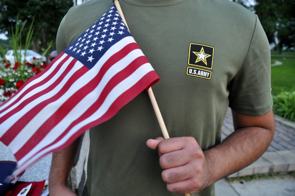 Immigration Service Discharges A Pakistani recruit, 22, who was recently discharged from the U.S. Army, holds an American flag as he poses for a picture. The man asked his name and location to be undisclosed for safety reasons. The AP interviewed three recruits from Brazil, Pakistan and Iran, all of whom said they were devastated by their unexpected discharges. (AP Photo/Mike Knaak)