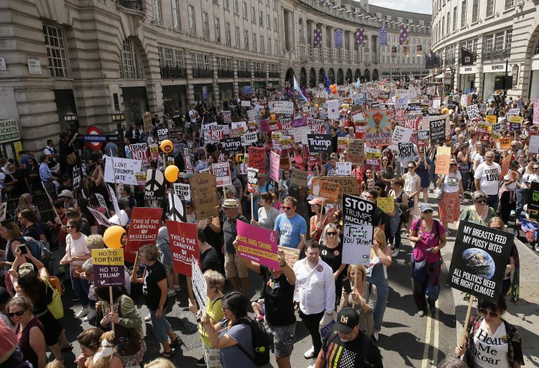 Protestors hold banners during a march opposed to the visit of U.S. President Donald Trump in London, Friday, July 13, 2018. (AP Photo/Tim Ireland)