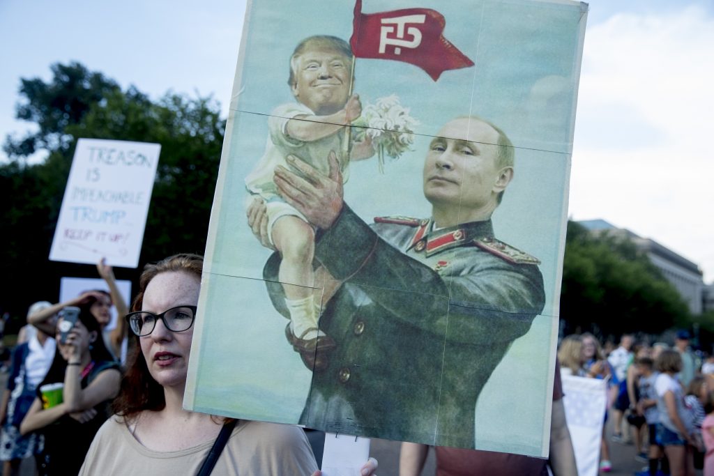 Trump A woman holds a sign depicting Russian President Vladimir Putin and President Donald Trump during a protest outside the White House following Trump's meetings with Putin. (Andrew Harnik/AP Photo)