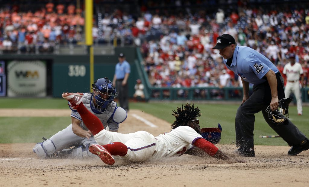 Odubel Herrera, Austin Barnes Philadelphia Phillies' Odubel Herrera, center, scores past Los Angeles Dodgers catcher Austin Barnes, left, on a three-run triple by Carlos Santana during the fifth inning of a baseball game, Wednesday, July 25, 2018, in Philadelphia. At right is umpire Adam Hamari. (AP Photo/Matt Slocum)
