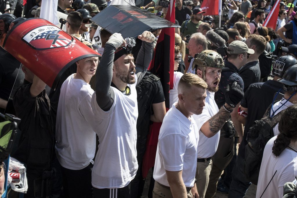 _I4A1693_1 Michael Miselis, standing in the crowd with both arms raised, was front and center during the violence in Charlottesville last summer. Miselis holds a national security clearance for his work with defense contractor Northrop Grumman. (Edu Bayer, special to ProPublica)