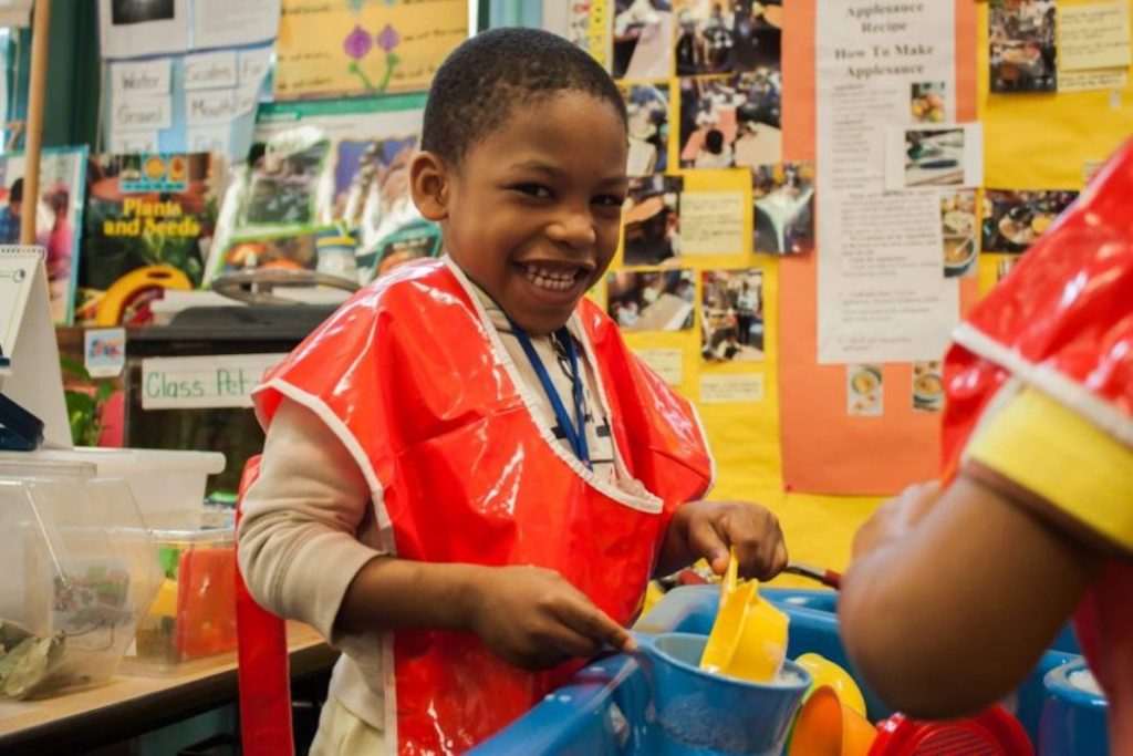 Lillian-Mongeau-Jamie-Martines-economics-prek–876×0-c-default Josiah Taft, 4, played at the water table in his public preschool classroom at P.S. 3 in Brooklyn in 2016. New York is one of a handful of big American cities that offer universal preschool. Photo: Jamie Martines for The Hechinger Report