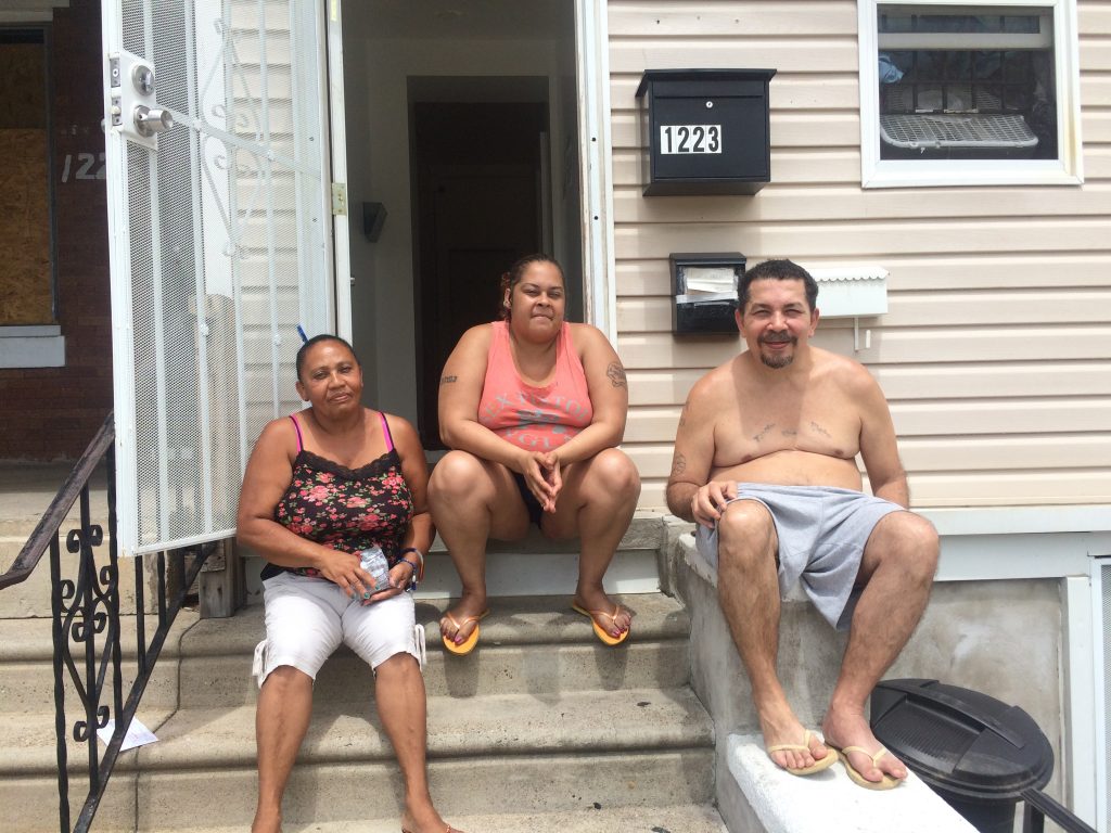 Ana Marrero, Milagros Soto, and Pablo Cuevas catching a cool breeze on the stoop of their home in Hunting Park. (Catalina Jaramillo/WHYY News)