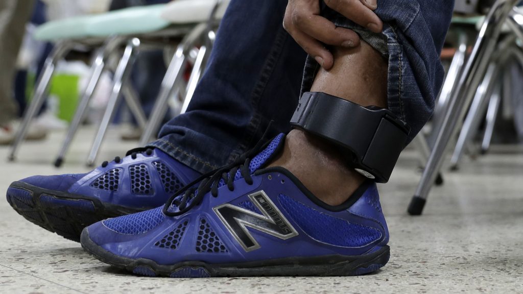 An immigrant wears an ankle monitor as he sits at a shelter in McAllen, Texas after he was released after processing by U.S. Customs and Border Protection. An immigrant wears an ankle monitor as he sits at a shelter in McAllen, Texas after he was released after processing by U.S. Customs and Border Protection. (Eric Gay/AP)